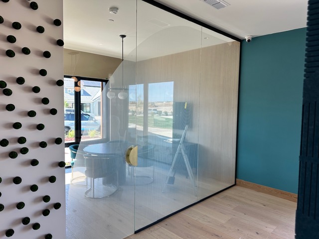 Conference room glass partition with decorative privacy film forming an arch pattern