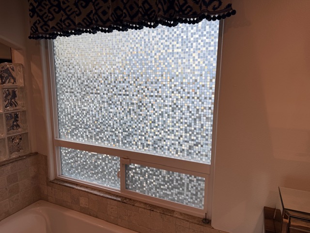 Decorative frosted film with a geometric pattern on a bathroom window